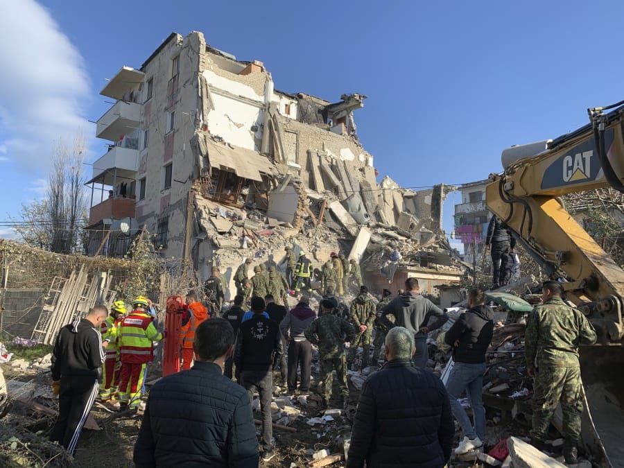 Rescuers search at a damaged building after a magnitude 6.4 earthquake in Thumane, western Albania, Tuesday, Nov. 26, 2019. Rescue crews used excavators to search for survivors trapped in toppled apartment buildings after a powerful pre-dawn earthquake in Albania killed at least six people and injured more than 300.