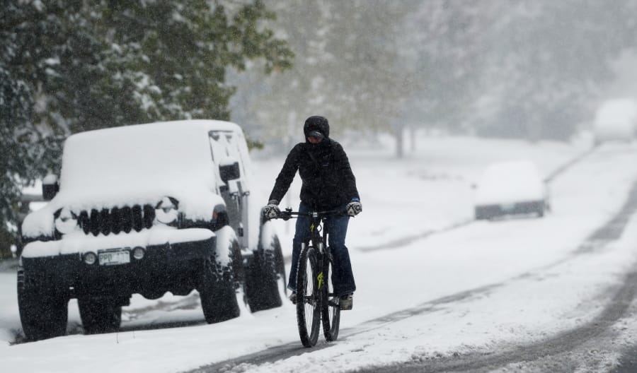 A bicyclist makes her way down South Monroe Street in Denver on Oct. 10 during the season&#039;s first snowstorm.