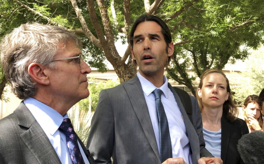 FILE - In this June 11, 2019, file photo, Scott Warren, center, speaks outside federal court, in Tucson, Ariz., after a mistrial was declared in the federal case against him. The second trial against Warren, a border activist accused of harboring immigrants in the country illegally, is set to start on Tuesday, Nov. 12, 2019.