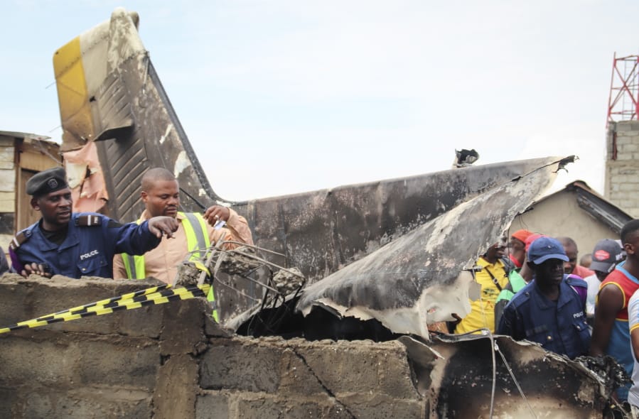 Rescuers and onlookers gather amidst the debris of an aircraft operated by private carrier Busy Bee which crashed in Goma, Congo Sunday, Nov. 24, 2019. The plane carrying at least 17 passengers crashed Sunday on takeoff in Congo&#039;s eastern city of Goma in North Kivu province, killing those on board, officials said, and possibly people on the ground after the aircraft crashed into residential homes.