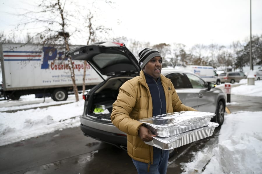 Abdirahman Kahin, owner of Afro Deli, donate food to residents of the Cedar Riverside, following a fire on the 14th floor of a public housing high-rise in Minneapolis on Wednesday, Nov. 27, 2019. Several people died and a few people were injured when the fire broke at the building in a heavily immigrant neighborhood of Minneapolis early Wednesday.