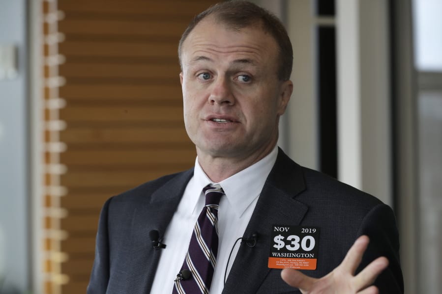 Anti-tax activist Tim Eyman talks to reporters Nov. 7 outside the office of Seattle Mayor Jenny Durkan in Seattle. Durkan said that the city would file a lawsuit to block the $30 car tab initiative sponsored by Eyman that was passed by Washington voters in last week&#039;s general election. Durkan said that if fully implemented, Initiative 976 would force the city to cut more than 100,000 bus hours and would hamper free bus access for students and low-income residents. (AP Photo/Ted S.