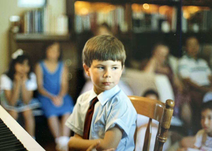 In this image provided by the Pete Buttigieg presidential campaign, Pete Buttigieg sits at a piano in a a Montessori graduation event for parents in South Bend, Ind., around 1987.