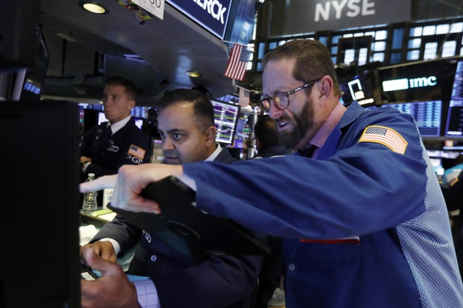Trader Stephen Gilmartin, right, works with specialist Dilip Patel on the floor of the New York Stock Exchange, Wednesday, Nov. 13, 2019. Stocks are opening slightly lower on Wall Street led by declines in banks and industrial companies.