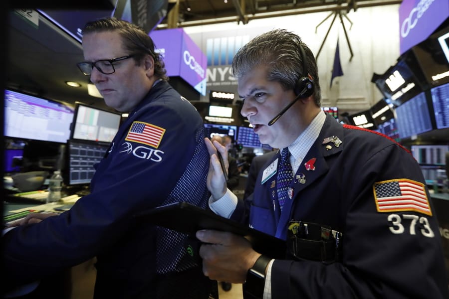 FILE - In this Tuesday, Oct. 29, 2019, file photo specialist Gregg Maloney, left, and trader John Panin work on the floor of the New York Stock Exchange. The U.S. stock market opens at 9:30 a.m. EDT on Friday, Nov. 1.