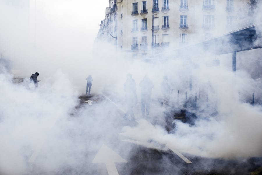 Tear gas envelopes protesters during a yellow vest demonstration marking the first anniversary in Paris, Saturday, Nov. 16, 2019.
