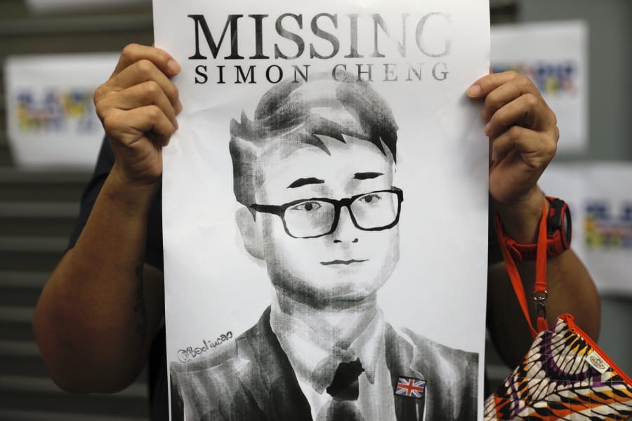 FILE - In this Aug. 21, 2019, file photo, a supporter holds a poster outside of the British Consulate in Hong Kong during a rally in support of an employee of the consulate who was detained while returning from a trip to China. A former employee of the British Consulate in Hong Kong says he was detained and tortured by Chinese secret police trying to extract information about massive anti-government protests in the territory.
