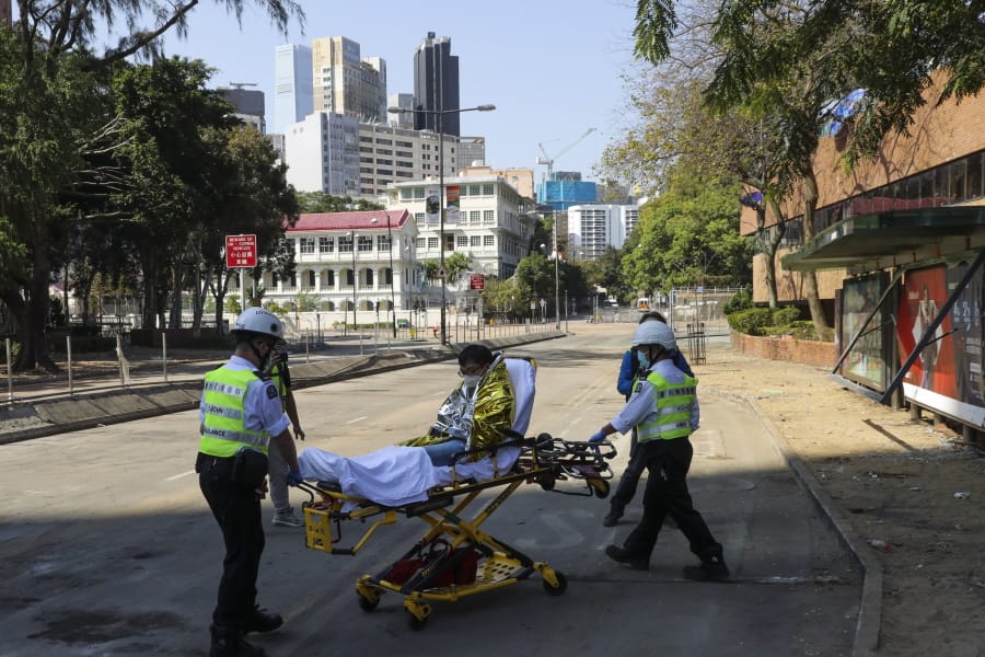 A protester is wheeled on a stretcher by first aid personnel as they leave the Polytechnic University campus in Hong Kong, Thursday, Nov. 21, 2019. A small group of protesters refused to leave Hong Kong Polytechnic University, the remnants of hundreds who took over the campus for several days.