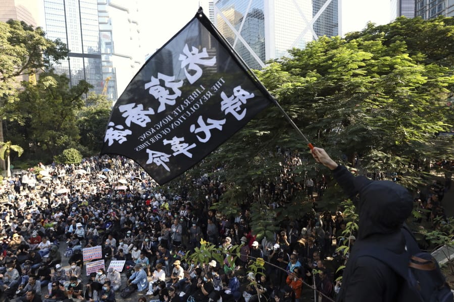 A protester waves a flag reading &quot;Liberate Hong Kong, the Revolution of Our Times&quot; at a rally Saturday for students and elderly pro-democracy demonstrators in Hong Kong.