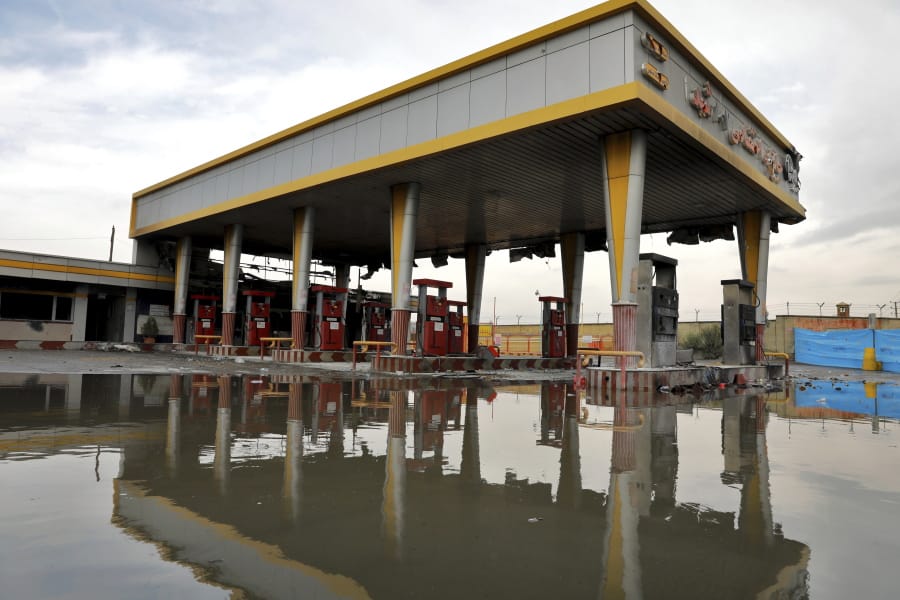 FILE - In this Nov. 20, 2019, file photo, a gas station that was attacked during protests over rises in government-set gasoline prices is reflected in a puddle, in Tehran, Iran. Internet connectivity is trickling back in Iran after the government shut down access to the rest of the world for more than four days in response to unrest apparently triggered by a gasoline price hike.