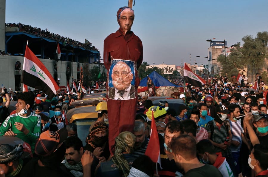 FILE - in this Wednesday, Oct. 30, 2019 file photo, Anti-government protesters hold an effigy of Iraqi Prime Minister Adel Abdel-Mahdi during ongoing protests in Baghdad, Iraq. Celebrations have erupted in Iraq&#039;s Tahrir Square, Friday, Nov. 29, where anti-government protesters have been camped out for nearly two months following an announcement by Iraqi Prime Minister Adel Abdul-Mahdi, would be resigning.