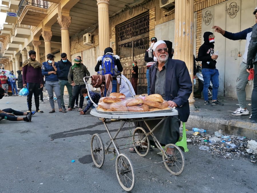 In this Tuesday, Nov. 26, 2019 photo, a street vendor sells cakes on Rasheed Street in Baghdad, Iraq. Baghdad&#039;s Rasheed Street was the scene of large marches by Iraqis against British occupiers nearly a century ago and now it&#039;s a front line in a new revolt.
