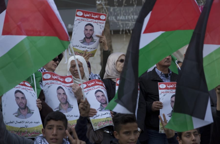 Protesters fly Palestinian flags and carry posters with pictures of Palestinian prisoner in Israeli jail, Sami Abu Diak, who died this morning, during a protest in the West Bank city of Ramallah, Tuesday, Nov. 26. 2019. Diak died Tuesday in Israeli custody after battling cancer, Israel&#039;s prisons service said, ahead of demonstrations in the West Bank planned before his death.