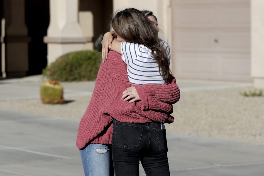 Madelyn Staddon, right, a relative of some of the members of a Mormon community who were attacked while traveling near the US-Mexico border, embraces a neighbor outside her home, Tuesday, Nov. 5, 2019, in Queen Creek, Ariz. Drug cartel gunmen ambushed three vehicles along a road near the state border of Chihuahua and Sonora on Monday, slaughtering at least six children and three women from the extended LeBaron family, all of them U.S. citizens living in northern Mexico, authorities said Tuesday.
