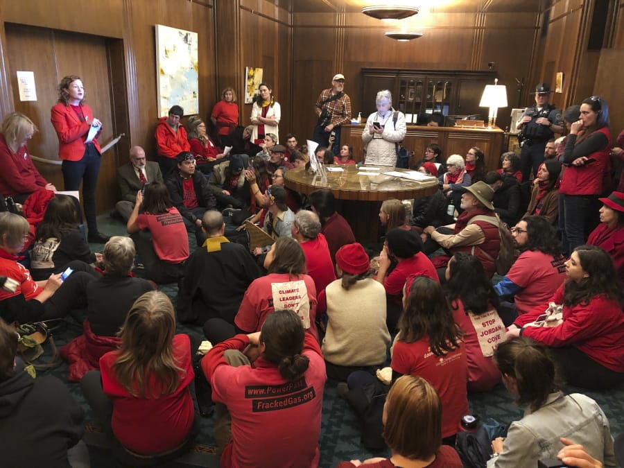 Demonstrators against a proposed liquid-natural gas pipeline and export terminal in Oregon sit in in the governor&#039;s office in the Oregon State Capitol on Thursday, Nov. 21, 2019, to demand Democratic Gov. Kate Brown stand against the proposal. They staged a sit-in at her office in the Capitol, but she was not present. The Jordan Cove pipeline is undergoing a permitting process. The pipeline would end at a proposed marine export terminal in Coos Bay, Oregon. Opponents say the pipeline would encourage further use of fossil fuels that leads to global warming and the use of fracking, with the risk of spills along the pipeline and at the terminal. Advocates for the project say it would produce jobs.