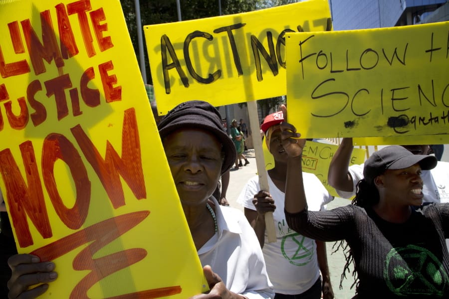 Demonstrator show their placards during climate change protest outside the Johannesburg Stock Exchange in Johannesburg, South Africa, Friday, Nov. 29, 2019.  Environmentalists around the world are joining a global day of protests Friday, in a symbolic gesture to demand that governments act against climate change.