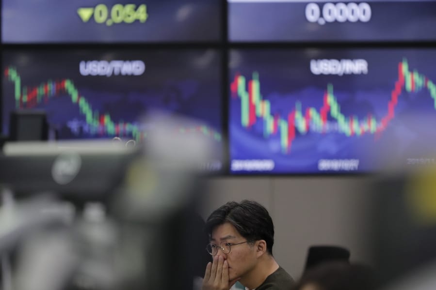 A currency trader watches computer monitors at the foreign exchange dealing room in Seoul, South Korea, Friday, Nov. 29, 2019. Shares extended losses in Asia on Friday after Japan and South Korea reported weak manufacturing data that suggest a worsening toll from trade tensions.
