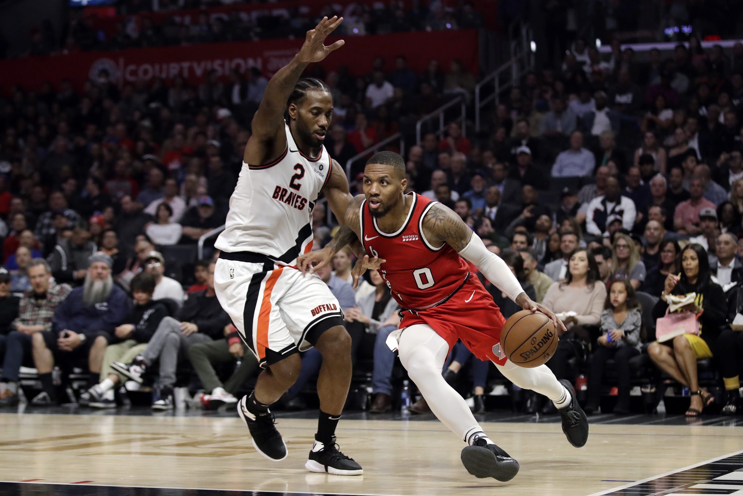 Portland Trail Blazers' Damian Lillard (0) dribbles next to Los Angeles Clippers' Kawhi Leonard (2) during the first half of an NBA basketball game Thursday, Nov. 7, 2019, in Los Angeles.