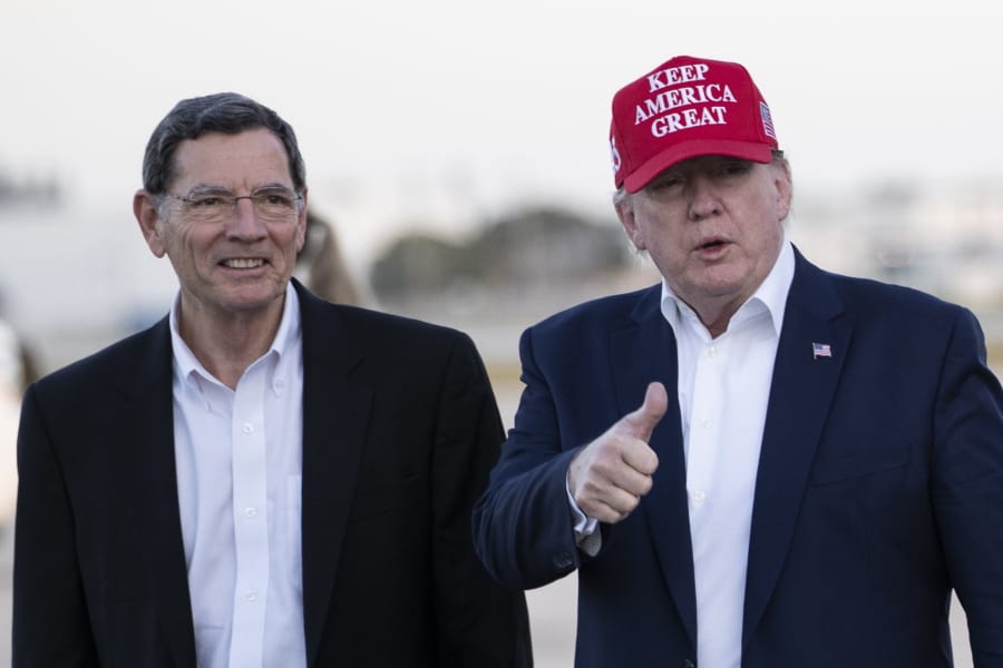 President Donald Trump gives thumbs up as he steps off Air Force One, accompanied by Sen. John Barrasso, R-Wyo., at the Palm Beach International Airport, Friday, Nov. 29, 2019, in West Palm Beach, Fla. Trump is returning from a trip to visit the troops in Afghanistan.