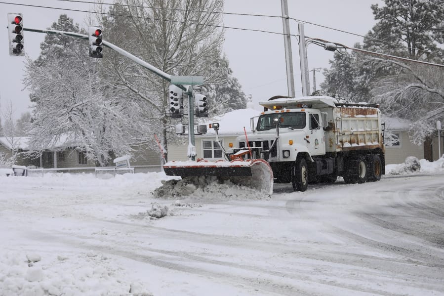 A city snowplow helps clear roads north of downtown Flagstaff, Ariz., Friday, Nov. 29, 2019. A powerful storm making its way east from California is threatening major disruptions during the year&#039;s busiest travel weekend, as forecasters warned that intensifying snow and ice could thwart millions across the country hoping to get home after Thanksgiving. The storm has already killed at least one person and shut down highways in the western U.S., stranding drivers in California and prompting authorities in Arizona to plead with travelers to wait out the weather before attempting to travel.