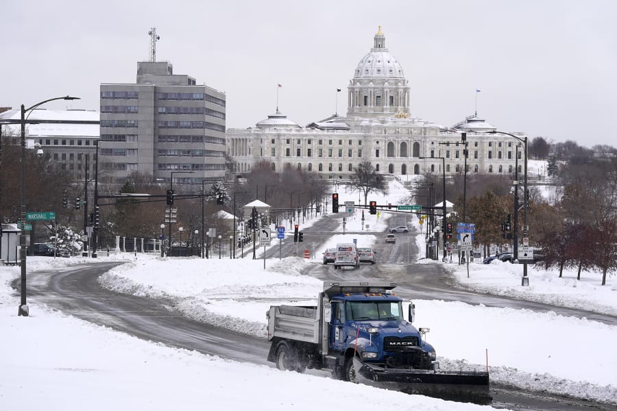 A plow truck makes its way up the hill in front of the Cathedral of St. Paul, with the Capitol building in the backdrop on Wednesday, Nov. 27, 2019, in St. Paul, Minn.