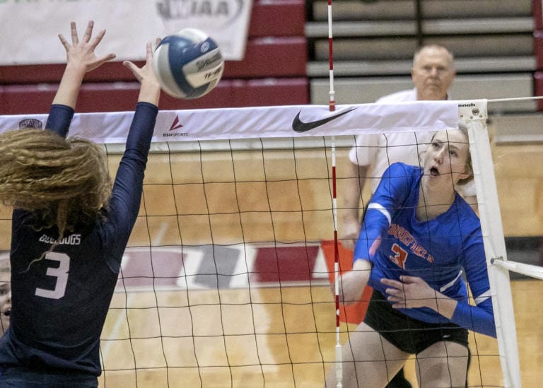 Ridgefield's Delaney Nicoll (3) spikes around Ellensburg's Grace Oldham (3) during the WIAA 2A girls state volleyball championship game on Saturday, Nov. 16, 2019, at the Nicholson Pavilion in Ellensburg, Wash. Ridgefield Spudders defeated the Ellensburg Bulldogs 3-1.
