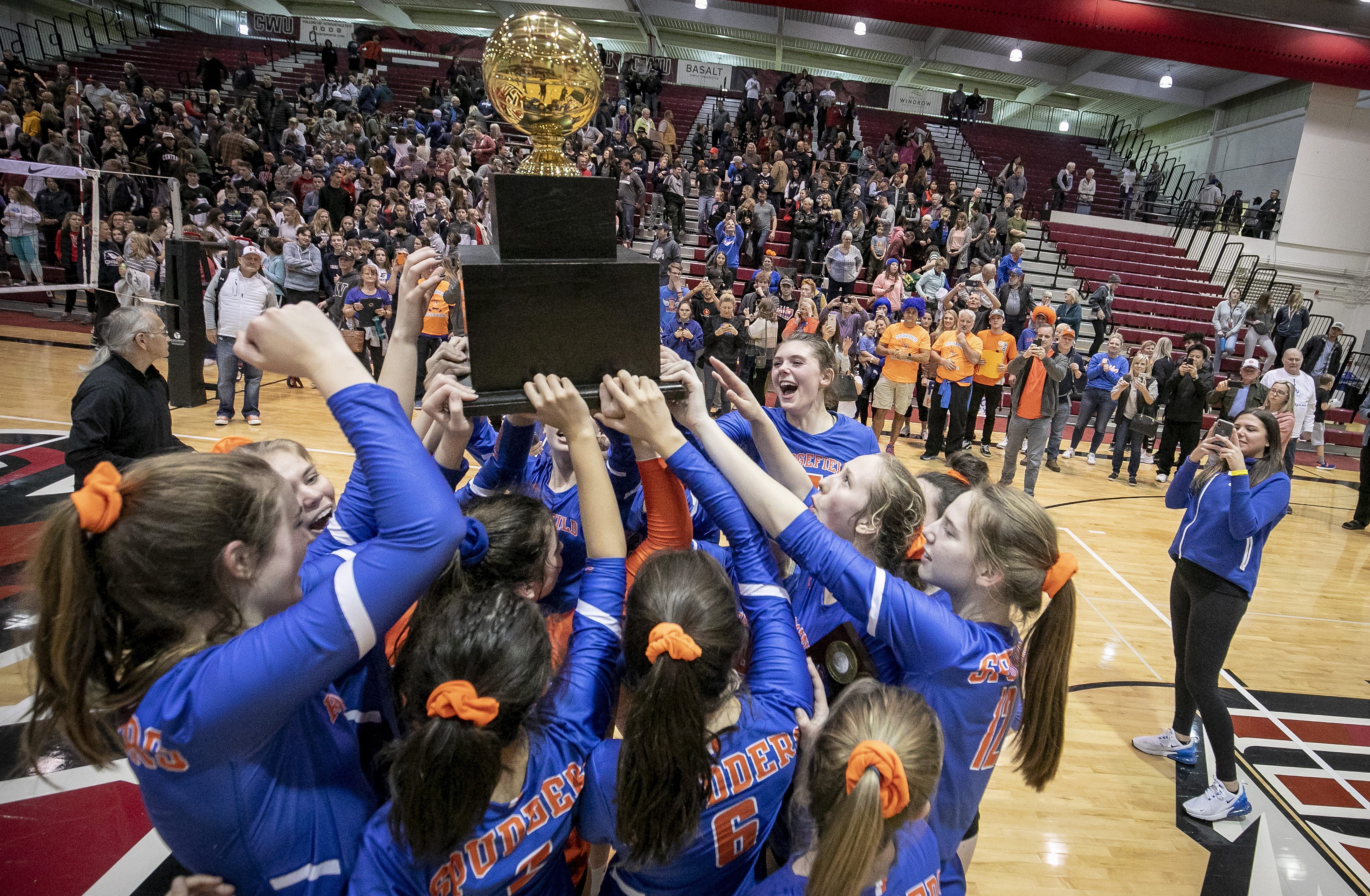 The Ridgefield High School volleyball team celebrates their WIAA 2A girls championship win with their fans after the Spudders defeats the Ellensburg Bulldogs 3-1 on Saturday, Nov. 16, 2019, at the Nicholson Pavilion in Ellensburg, Wash.