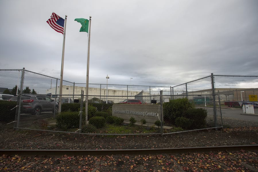 The American flag flies next to the official flag of the state of Washington outside the Northwest ICE Processing Center in Tacoma on Friday, Oct. 25, 2019.