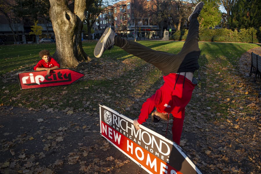 Sign spinner Jeremiah Zueger, left, and Chance Jordan, general manager of AArrow Sign Spinners practice in Esther Short Park in Vancouver on a recent November afternoon.