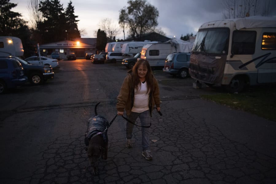 Lori Cuevas walks her dog up to the entrance of Sam&#039;s Good RV Park on Highway 99 in Hazel Dell on Nov. 25. She said she doesn&#039;t want to move from the park where she&#039;s lived for about 13 years.