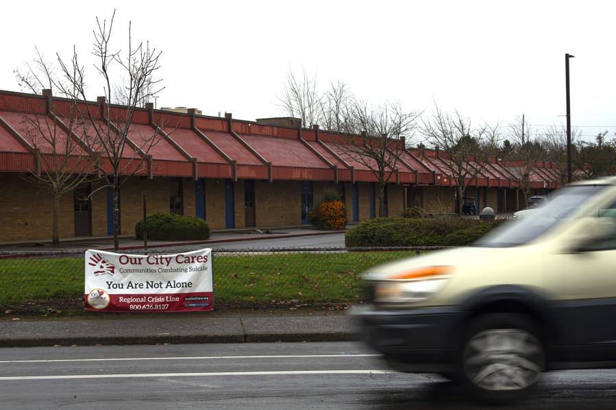 A car drives past an Our City Cares sign at Mountain View High School. Evergreen Public Schools is among the districts that have displayed the organization&#039;s signs to raise awareness of resources available for students experiencing mental health crises.