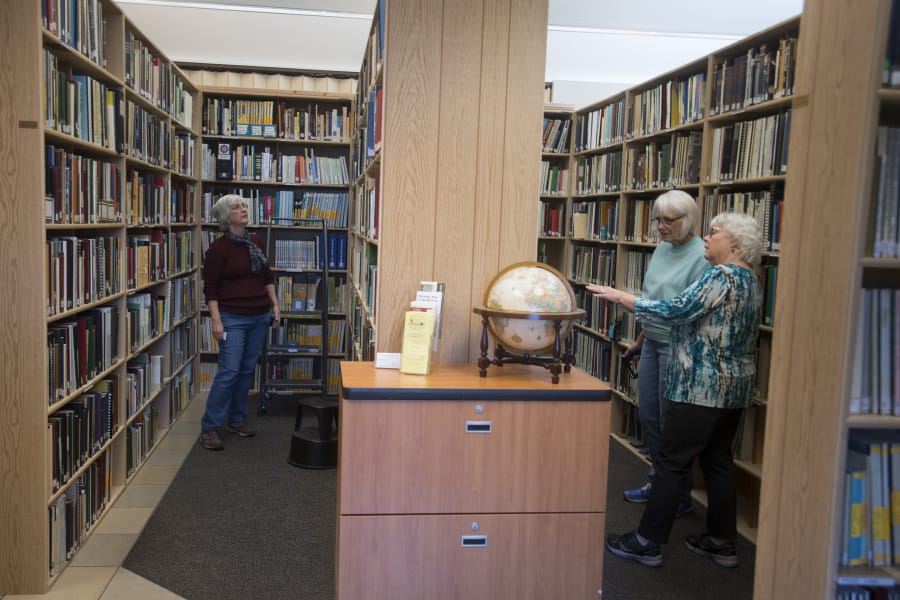 Marcia Grubb, from left, education director for the Clark County Genealogical Society, looks through books in the library of the organization&#039;s new facility with volunteers Sharon Cleveland and Barbara Schrag on Thursday.