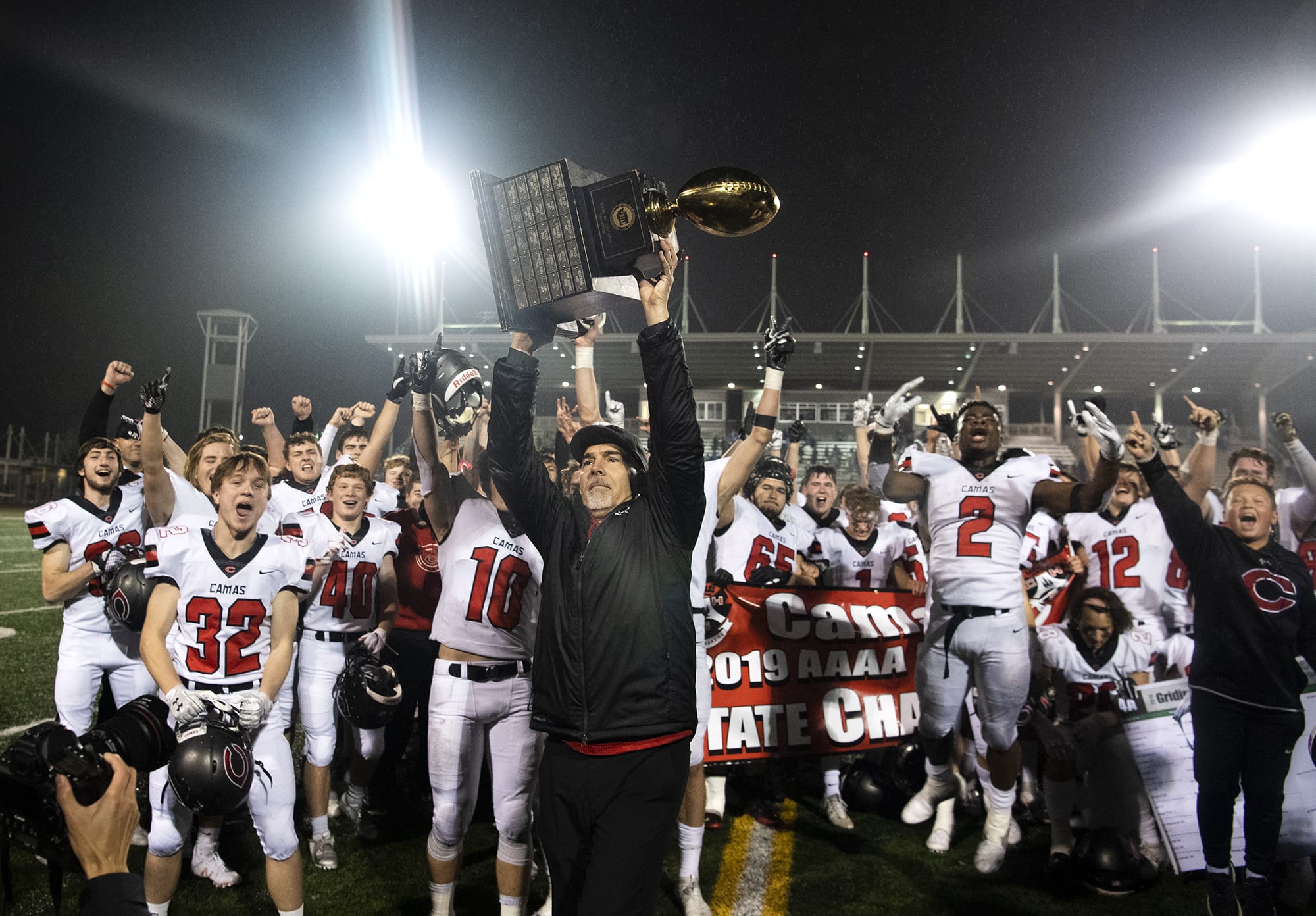 Camas head coach Jon Eagle hoists the trophy into the air after SaturdayÕs win in the Class 4A state championship game against Bothell at Mount Tahoma High School in Tacoma on Dec. 7, 2019.