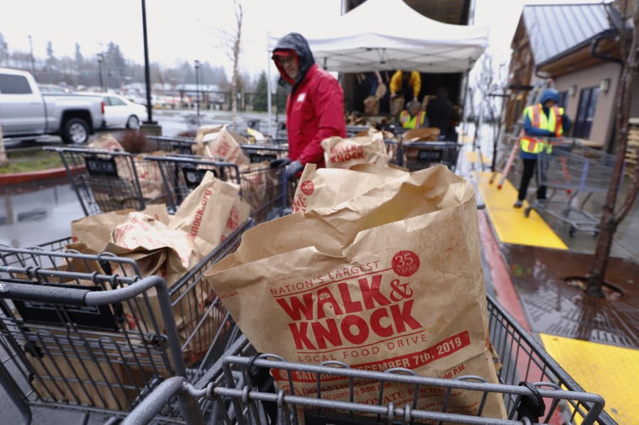 Bags of shelf-stables foods fill numerous shopping carts at the Walk &amp; Knock food drive at Chuck&#039;s Produce on Saturday. Chuck&#039;s was one of 10 drop-off sites for the food drive.