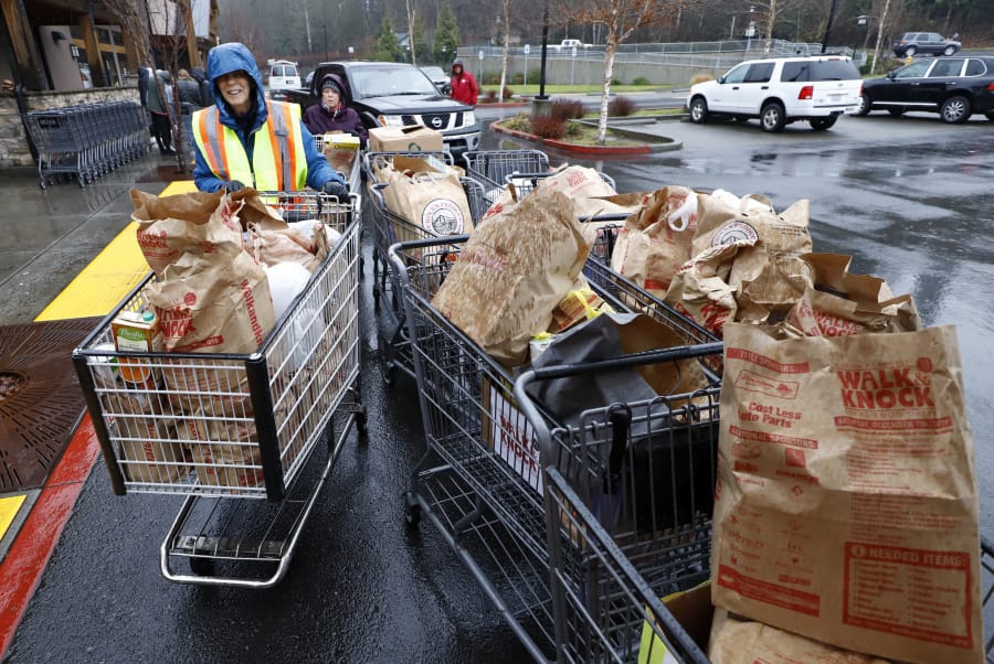 Marge Boulden, left, helps unload donated food at Chuck&#039;s Produce during the annual Walk &amp; Knock food drive.
