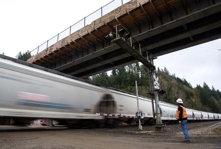Mick Cannon, a superintendent for Ceccanti Inc. of Tacoma, waits for a fast-moving train before Monday&#039;s opening of a concrete bridge spanning the railroad tracks and Lake River at the Ridgefield National Wildlife Refuge.