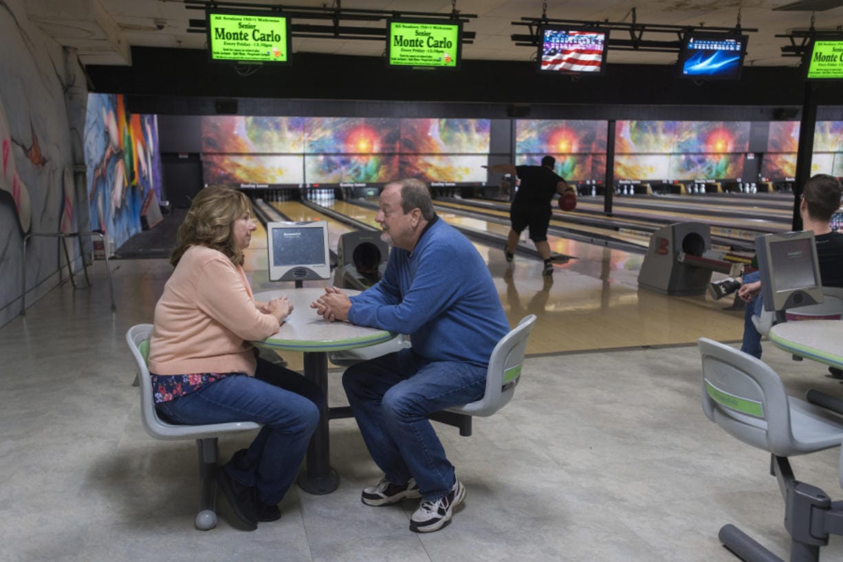 Rachael and Don Allen, owners of Allen's Crosley Lanes, chat inside their bowling alley as customers test their skill nearby Wednesday. A yearlong moratorium on new development along Evergreen and Grand boulevards has taken property owners by surprise, including the Allens, who had a buyer on the property fall through as a result. The family has owned and operated the bowling alley since 1987.