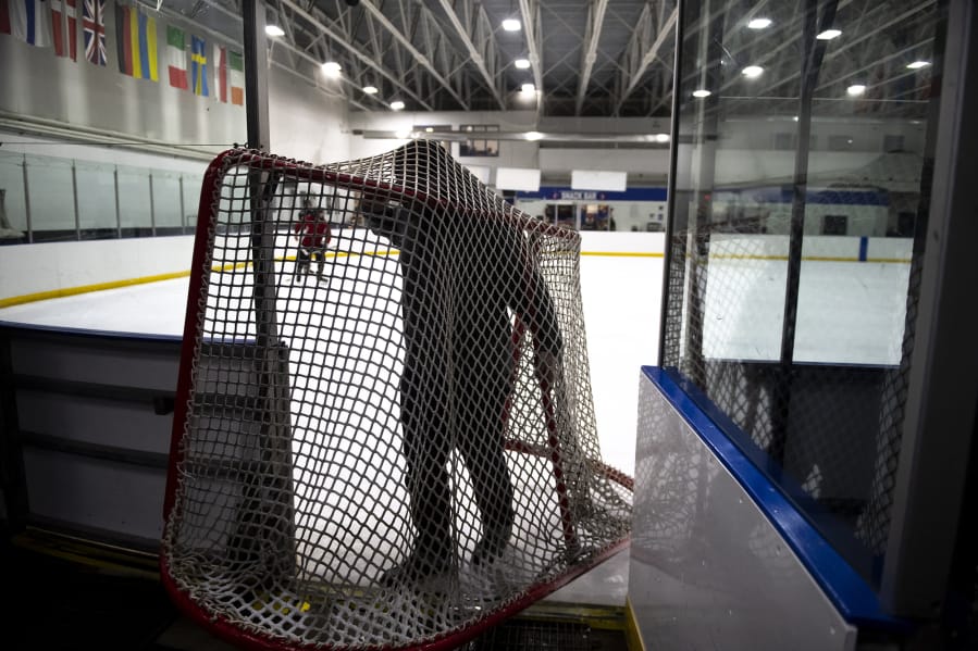 Brennan Bloemke carries hockey nets off the ice before resurfacing the rink at Mountain View Ice Arena.