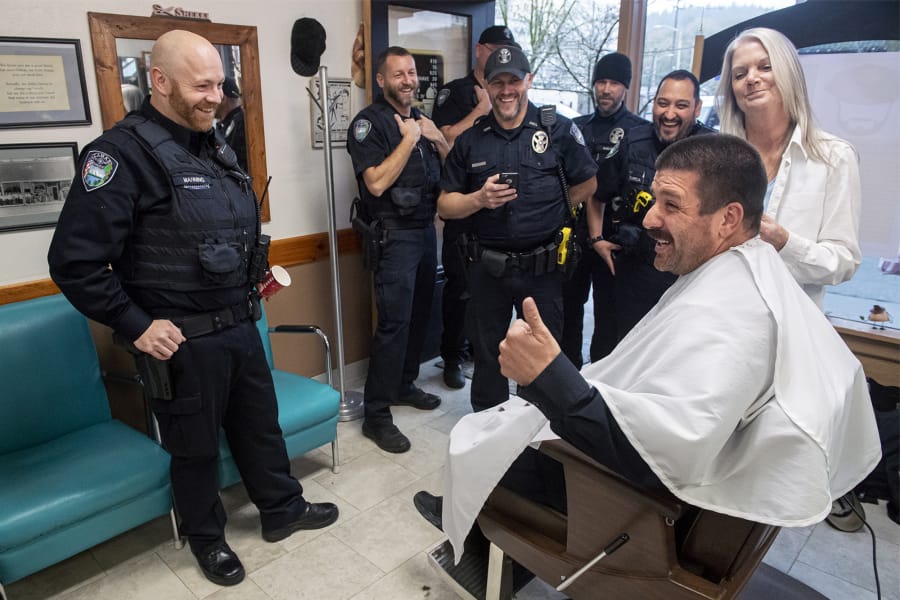 Camas police Officer Carlos Gonzalez, seated, reacts to his new mustache with other members of the Camas police force during a beard shaving fundraiser at Camas Barbershop on Wednesday. Cops in the department grew out their beards during No Shave November, and teamed with the barbershop to raise money on Wednesday for www.zerocancer.org, a nonprofit looking to end prostate cancer.