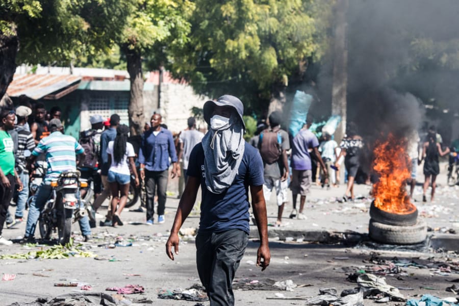 Protesters burn tires as they march in the street demanding the resignation of President Jovenel Moise in the Haitian capital in Port-au-Prince on Oct. 28, 2019.