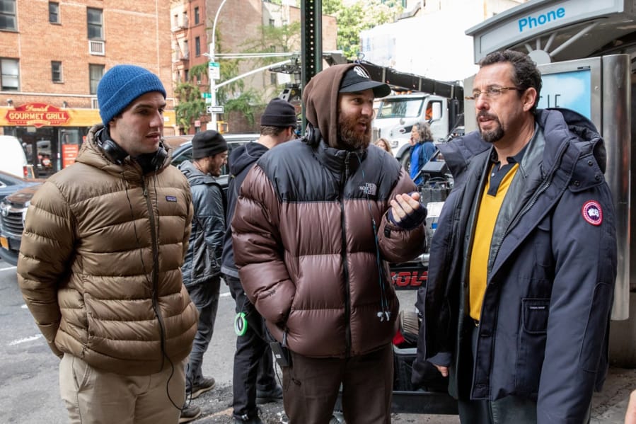 From left, writer-directors Benny and Josh Safdie chat with Adam Sandler on the set of &quot;Uncut Gems.&quot; (Julieta Cervantes/A24)