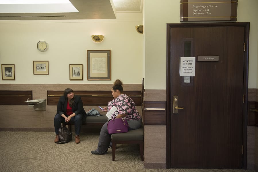 Kate Dunphy, left, deputy director of the Tenants Union of Washington, works with Charmaine Crossley following a hearing in her eviction case at Clark County Courthouse in October 2017.
