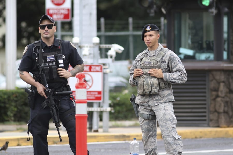 Security stands guard outside the main gate at Joint Base Pearl Harbor-Hickam, in Hawaii, Wednesday, Dec. 4, 2019. A shooting at Pearl Harbor Naval Shipyard in Hawaii left at least one person injured Wednesday, military and hospital officials said. Joint Base Pearl Harbor-Hickam spokesman Charles Anthony confirmed that there was an active shooting at Pearl Harbor Naval Shipyard.