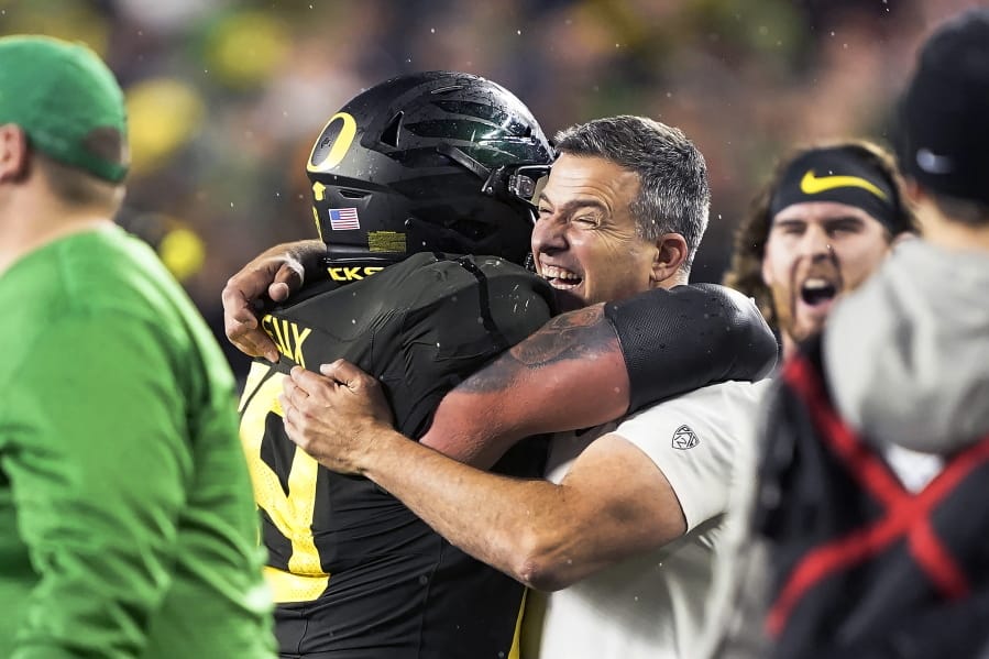 FILE - In this Dec. 6, 2018, file photo, Oregon coach Mario Cristobal, right, celebrates with offensive lineman Shane Lemieux (68) after Oregon defeated Utah 37-15 in an NCAA college football game for the Pac-12 Conference championship, in Santa Clara, Calif. Cristobal was named The Associated Press Pac-12 Coach of the Year Thursday, Dec. 12, 2019.