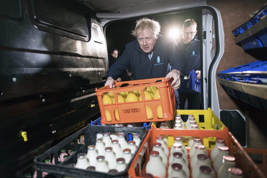 Britain&#039;s Prime Minister Boris Johnson loads a crate into a milk delivery van during a visit to Greenside Farm Business Park, as he campaigns for votes on the last day of campaigning ahead of Thursday&#039;s General Election, in Leeds, England, early Wednesday Dec. 11, 2019.  Britain goes to the polls in a General Election on Dec. 12.