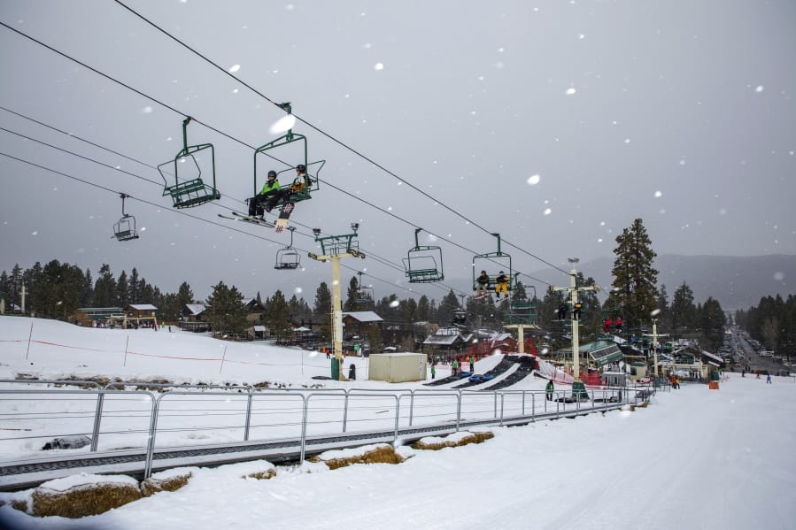 Snowboard and ski enthusiasts ride a lift to the slopes Monday at Big Bear Mountain Resort in Big Bear, Calif.