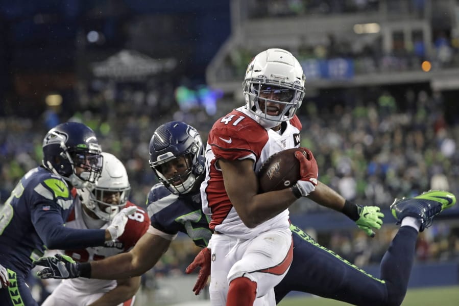 Arizona Cardinals running back Kenyan Drake gets past Seattle Seahawks outside linebacker K.J. Wright, center, to rush for a touchdown during the second half of an NFL football game, Sunday, Dec. 22, 2019, in Seattle.