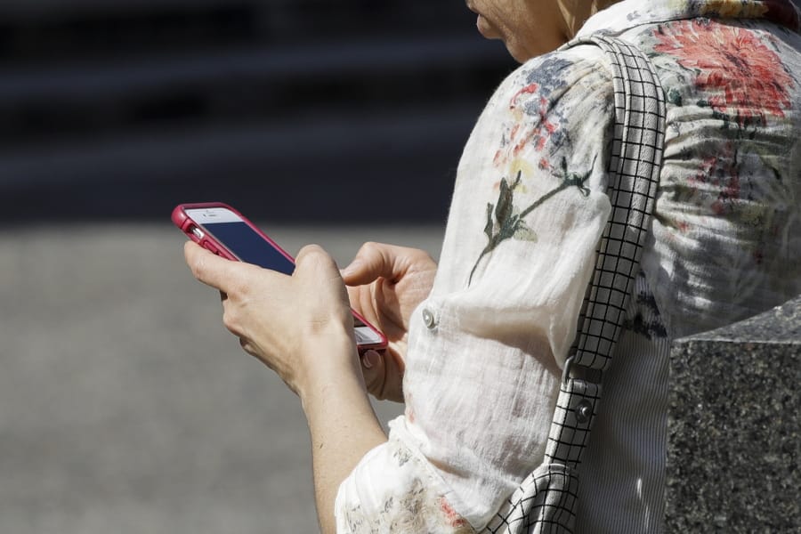 FILE - In this April 8, 2019, file photo, a woman browses her smartphone in Philadelphia. Accidental cuts and bruises to the face, head and neck from cellphones are sending increasing numbers of Americans to the emergency room, according to a study that estimates 76,000 cases over nine years.