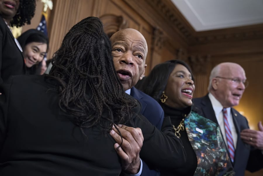 Civil rights leader Rep. John Lewis, D-Ga., is hugged as House Democrats gathered before passing the Voting Rights Advancement Act to eliminate potential state and local voter suppression laws, at the Capitol in Washington, Friday, Dec. 6, 2019. At right is Rep. Terri Sewell, D-Ala., who introduced the bill and who represents Selma, Ala., a city that was at the forefront of the 1960s civil rights movement. They are joined at far right by Sen. Patrick Leahy, D-Vt. (AP Photo/J.