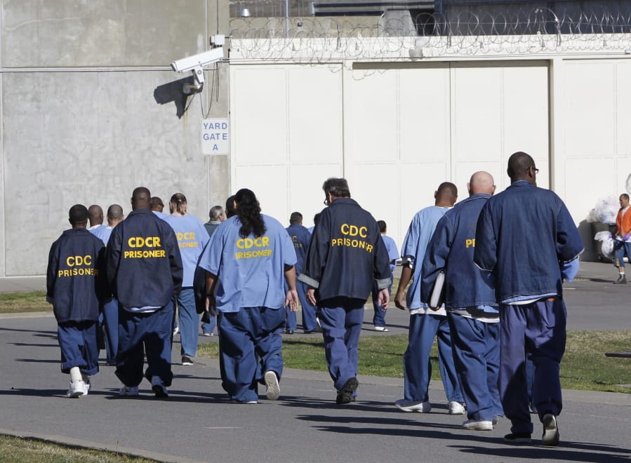 FILE - In this Feb. 26, 2013, file photo, inmates walk through the exercise yard at California State Prison Sacramento, near Folsom, Calif. Racial disparities have narrowed across the United States criminal justice system since 2000, though blacks remain significantly more likely to be impacted than whites, according to a study released Tuesday, Dec. 3, 2019, by the nonpartisan Council on Criminal Justice.